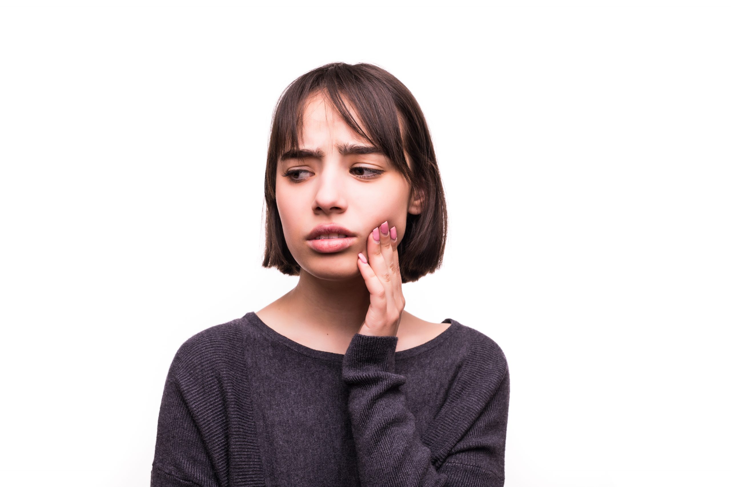 Teen woman pressing her bruised cheek with a painful expression. Teen having a terrible tooth ache.
