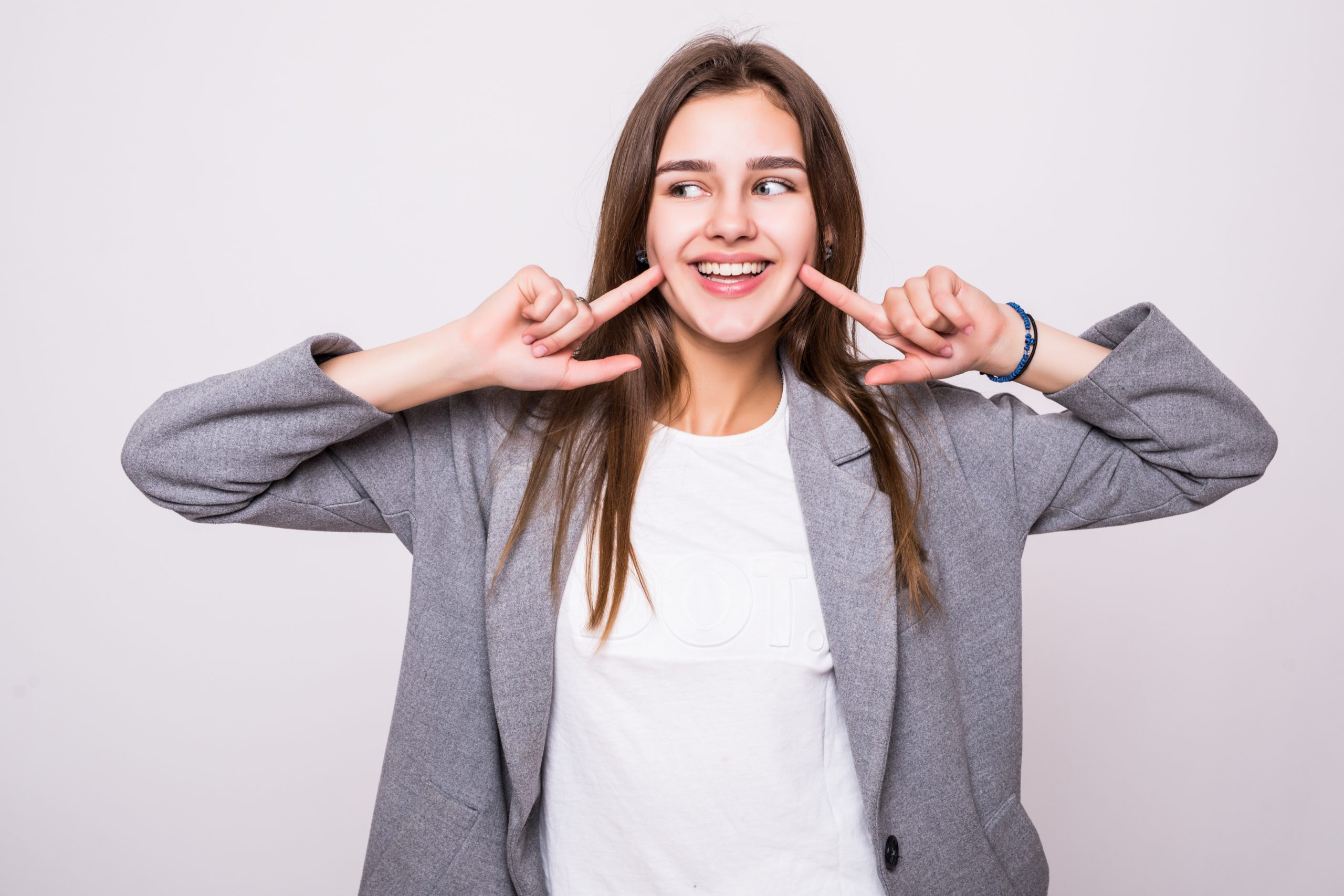 Woman showing her perfect straight white teeth on white background