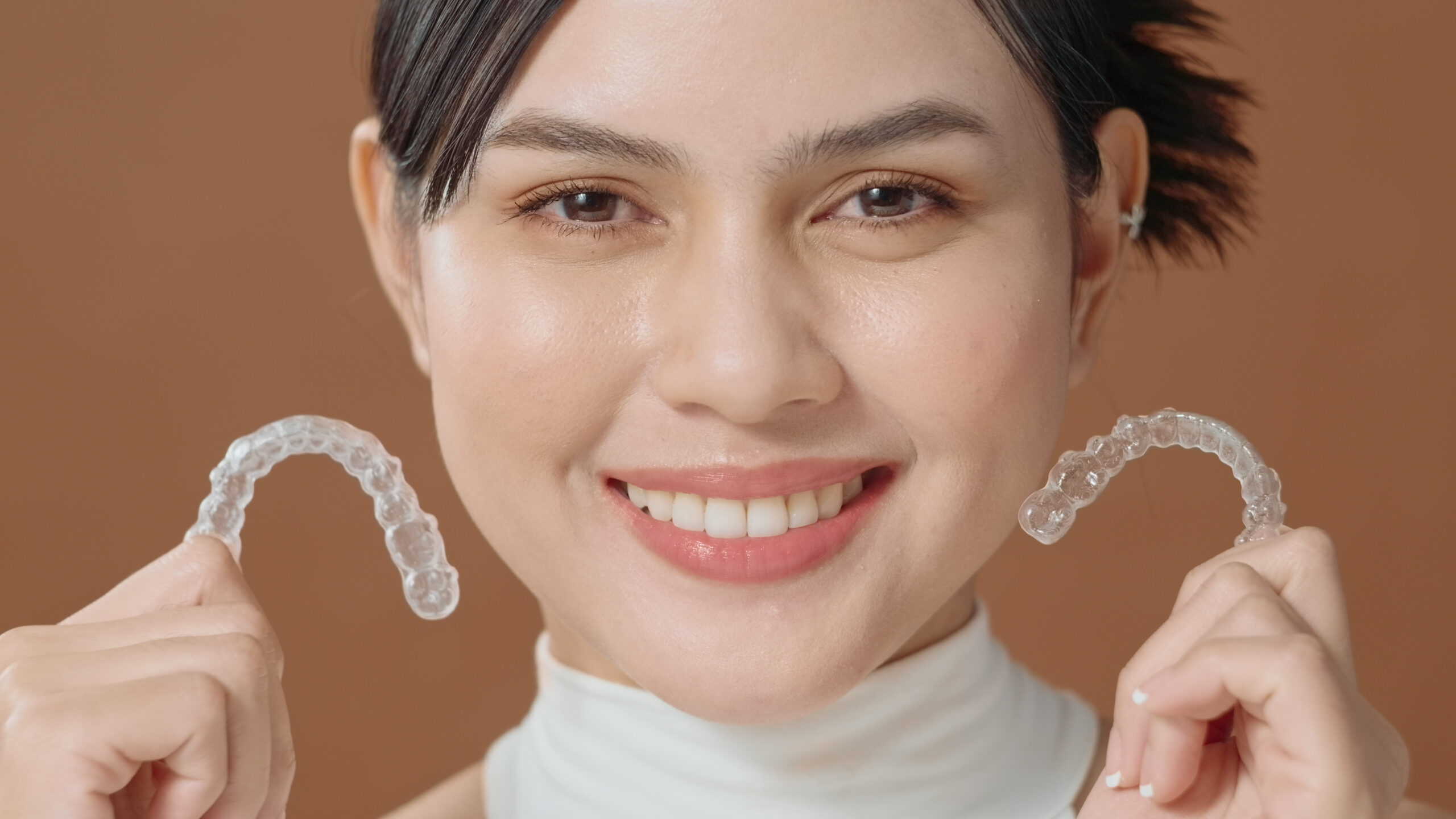 a-young-woman-with-beautiful-teeth-is-holding-invi-2023-11-27-05-16-32-utc.mov.01_10_56_00.Still001