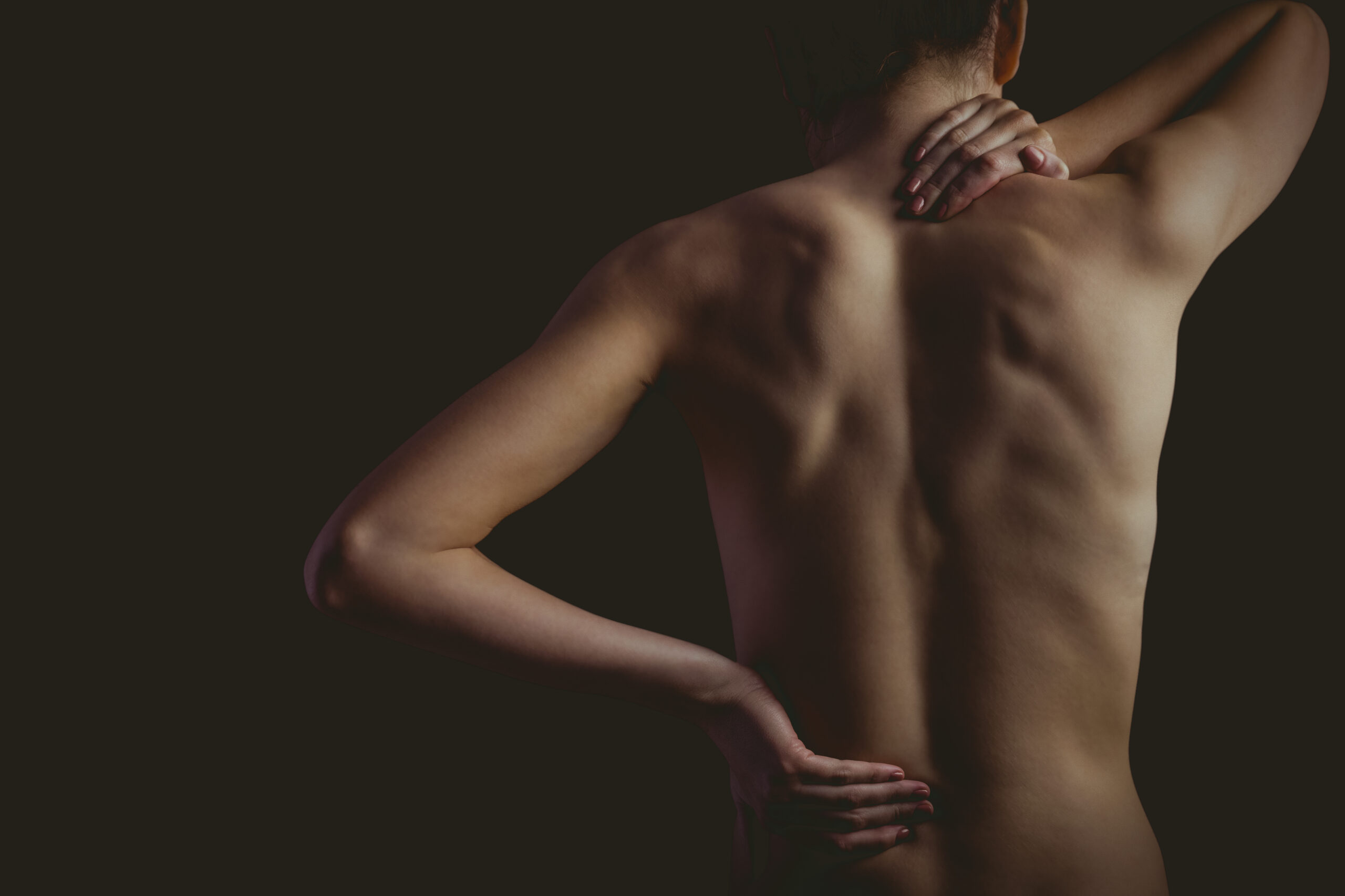 Nude woman with a neck injury on black background
