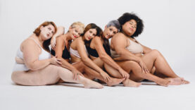 group of multi ethnic women in underwear, sitting in profile in row lying quietly between themselves