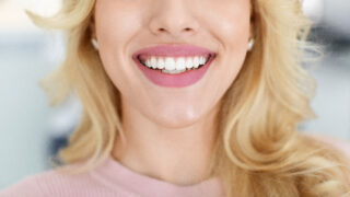 Blonde lady showing beautiful white teeth, cropped