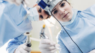 Dentist and dental nurse treating patient, personal perspective