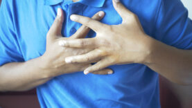 young man suffering pain in heart and holding chest with hand