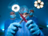 Woman doctor wearing uniform and gloves making x sign with scalpels in surgery