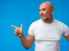 Handsome middle age mature man pointing to copy space