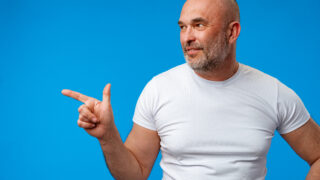 Handsome middle age mature man pointing to copy space