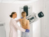 Female doctor prepairing woman before doing mammogram x-ray to check for breast cancer at hospital