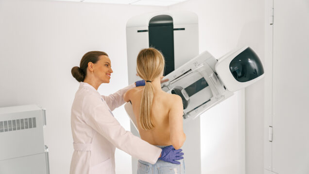 Female doctor prepairing woman before doing mammogram x-ray to check for breast cancer at hospital
