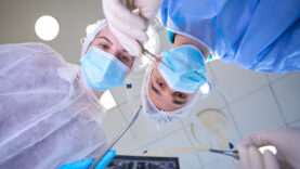 Male surgeon holds a special surgical needle in his hands