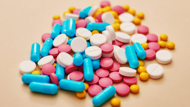 Assorted pharmaceutical medicine pills, tablets and capsules on beige background. Heap of various pills. Coronovirus, quarantine, epidemic, pandemic, flu, cold,illness. Medicine concept and health