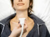 Doctor examining thyroid of female patient with ultrasound scan in clinic
