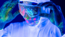 Portrait of man doctor in protective clothes in ultraviolet neon light during coronavirus pandemic.