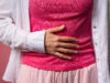 Young woman squeezing belly with hands. abdominal pain, suffering stomach ache