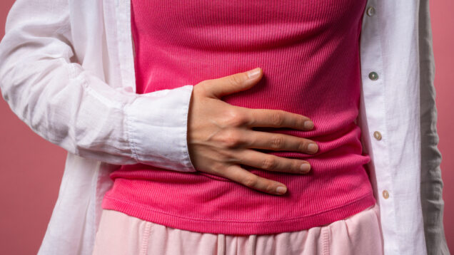 Young woman squeezing belly with hands. abdominal pain, suffering stomach ache