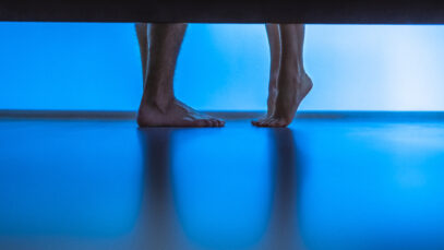 The legs of man and a woman near the bed. evening night time